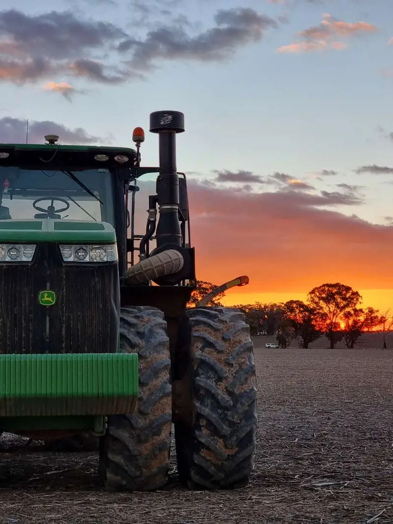 Tractor and landforming equipment lit up at dusk